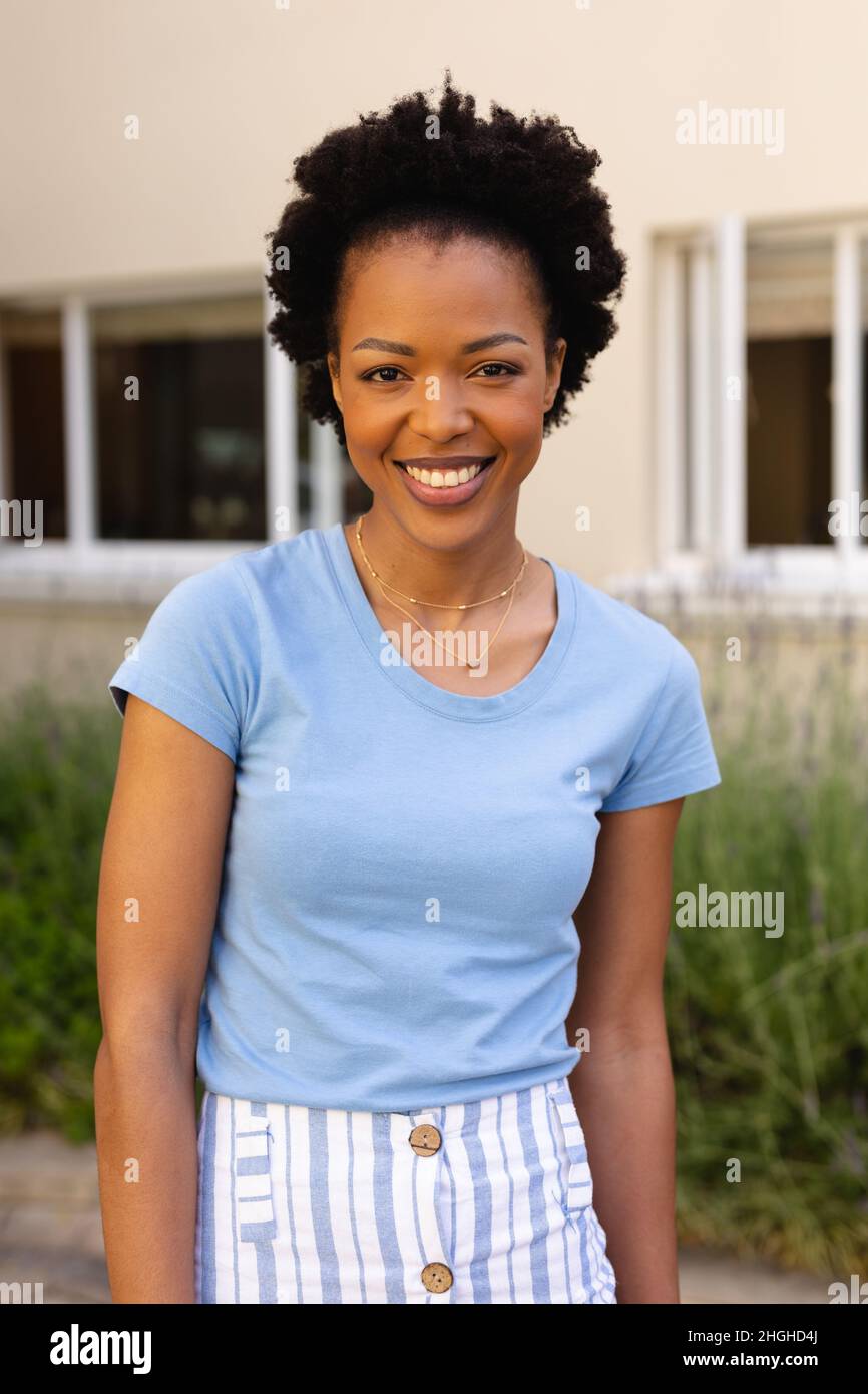 Portrait of happy african american young afro woman smiling while standing outdoors Stock Photo