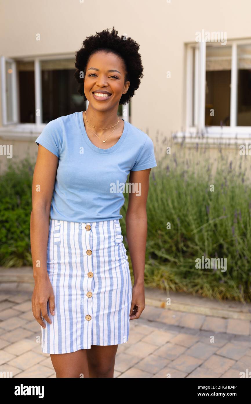 Portrait of happy african american young woman smiling while standing outdoors Stock Photo