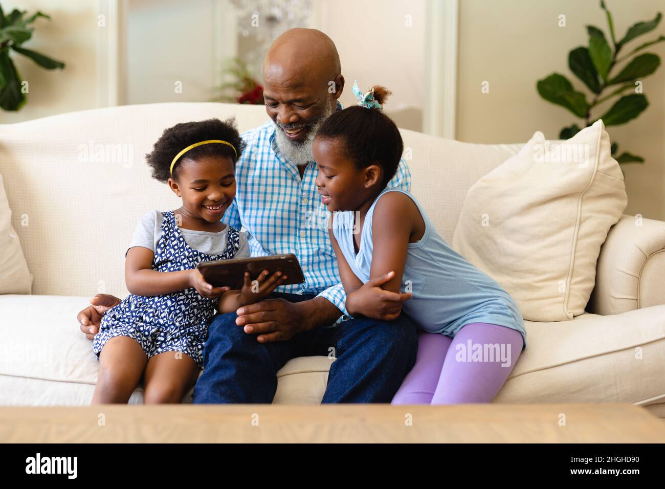African american grandfather and his two granddaughters using digital tablet at home Stock Photo