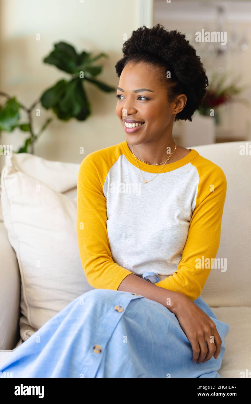 African american young woman smiling sitting on the couch at home Stock ...
