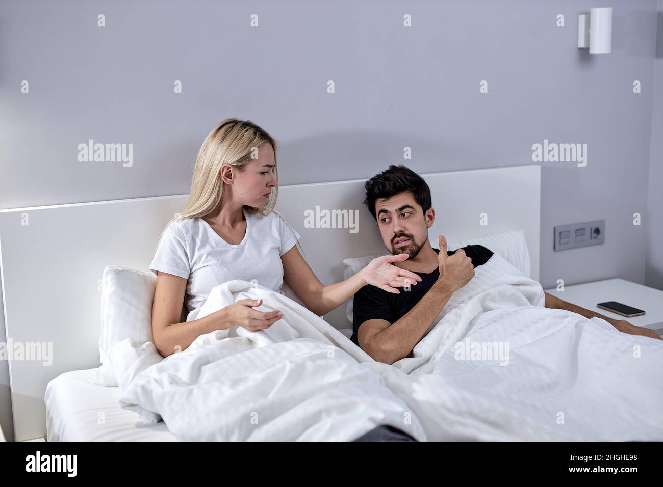 frustrated couple have scandal woman screaming at man fault mistake guy show sign reject refuse scream in bed in cozy bedroom in house indoors, man an Stock Photo