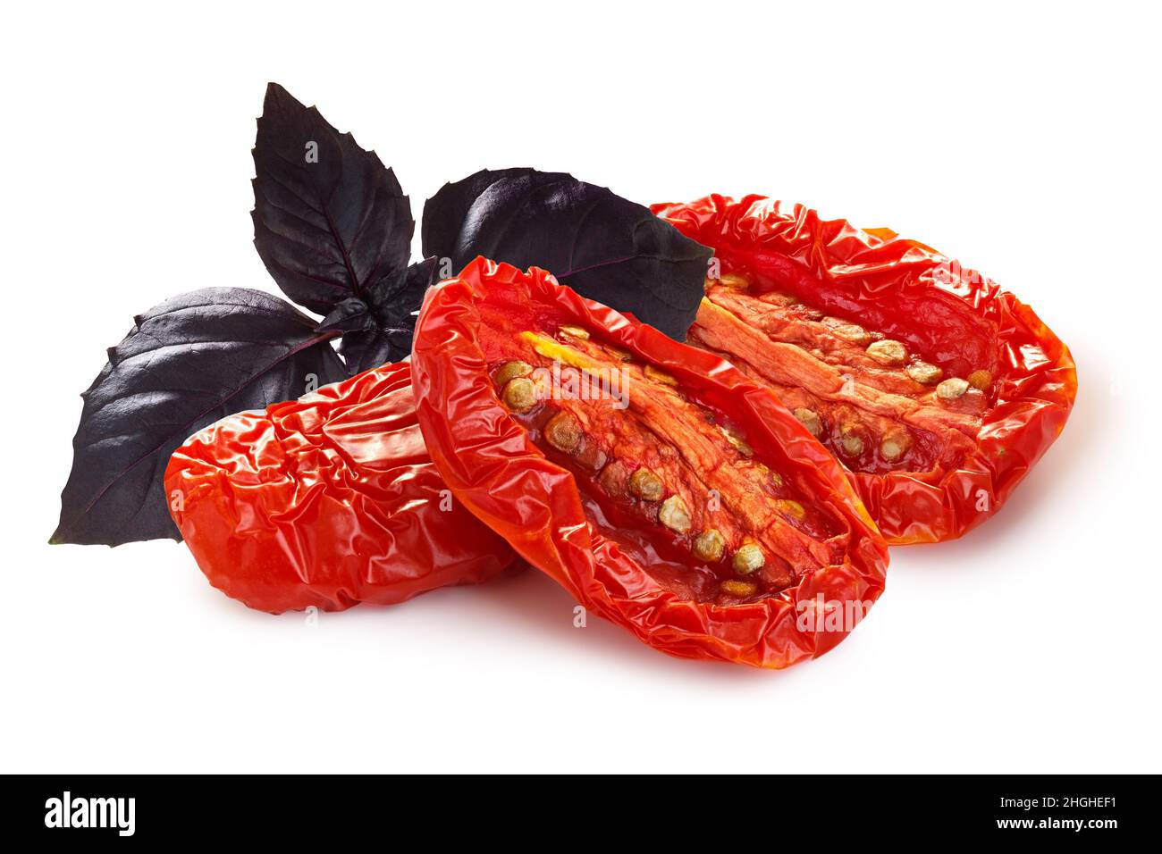 Dried or Sundried tomato halves with purple basil isolated Stock Photo