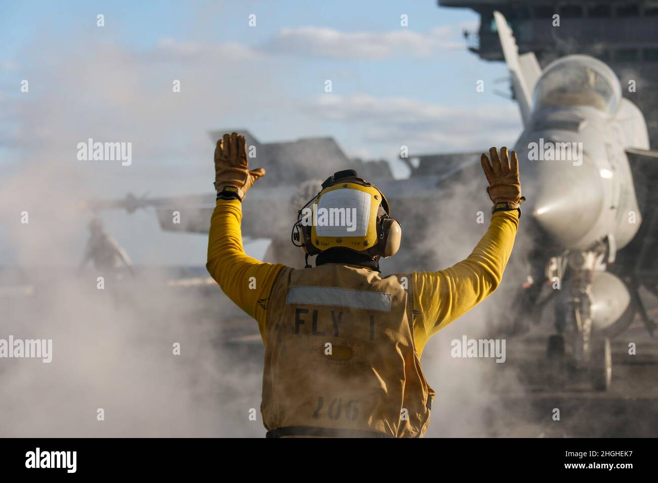 PACIFIC OCEAN (Jan. 17, 2022) Aviation Boatswain's Mate (Handling) 1st Class Melvin Dominguez, from Tujunga, Calif., directs an F/A-18E Super Hornet, assigned to the “Vigilantes” of Strike Fighter Squadron (VFA) 151, on the flight deck of USS Abraham Lincoln (CVN 72). Abraham Lincoln Strike Group is on a scheduled deployment in the U.S. 7th Fleet area of operations to enhance interoperability through alliances and partnerships while serving as a ready-response force in support of a free and open Indo-Pacific region. Stock Photo