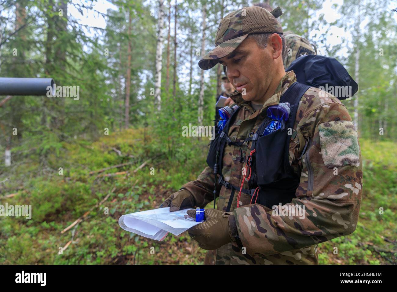 Col. Ryan “MZ” Montanez, 7th Air Force, looks at the map to determine his team's next point during the Interallied Confederation of Reserve Officers military competition in Lahti, Finland on August 1st. Teams were given several different maps and tasked with find control points in the woods. The CIOR MILCOMP is an annual competition among NATO and Partnership for Peace nations. This competition test reserve service members from allied nations on several core disciplines in teams of three. Stock Photo