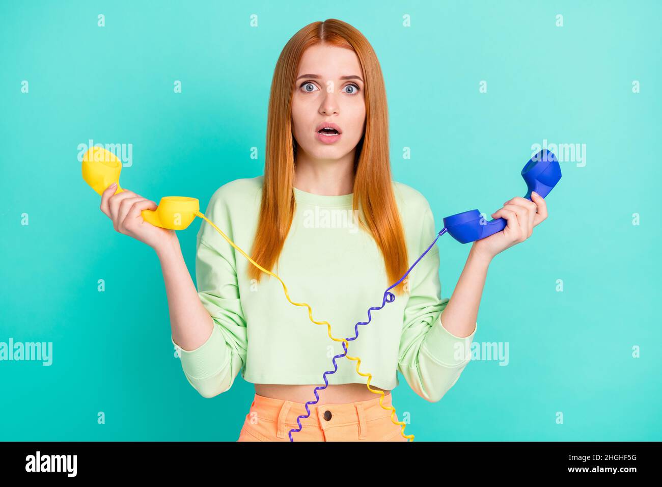 Photo of stressed millennial lady hold phones wear sport clothes isolated on vivid teal color background Stock Photo