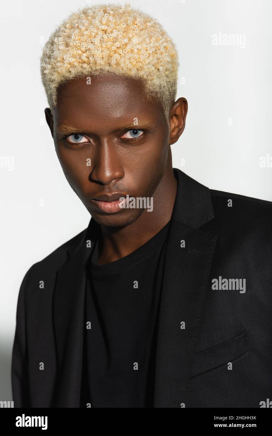 young african american man with blonde hair looking at camera isolated on  grey Stock Photo - Alamy