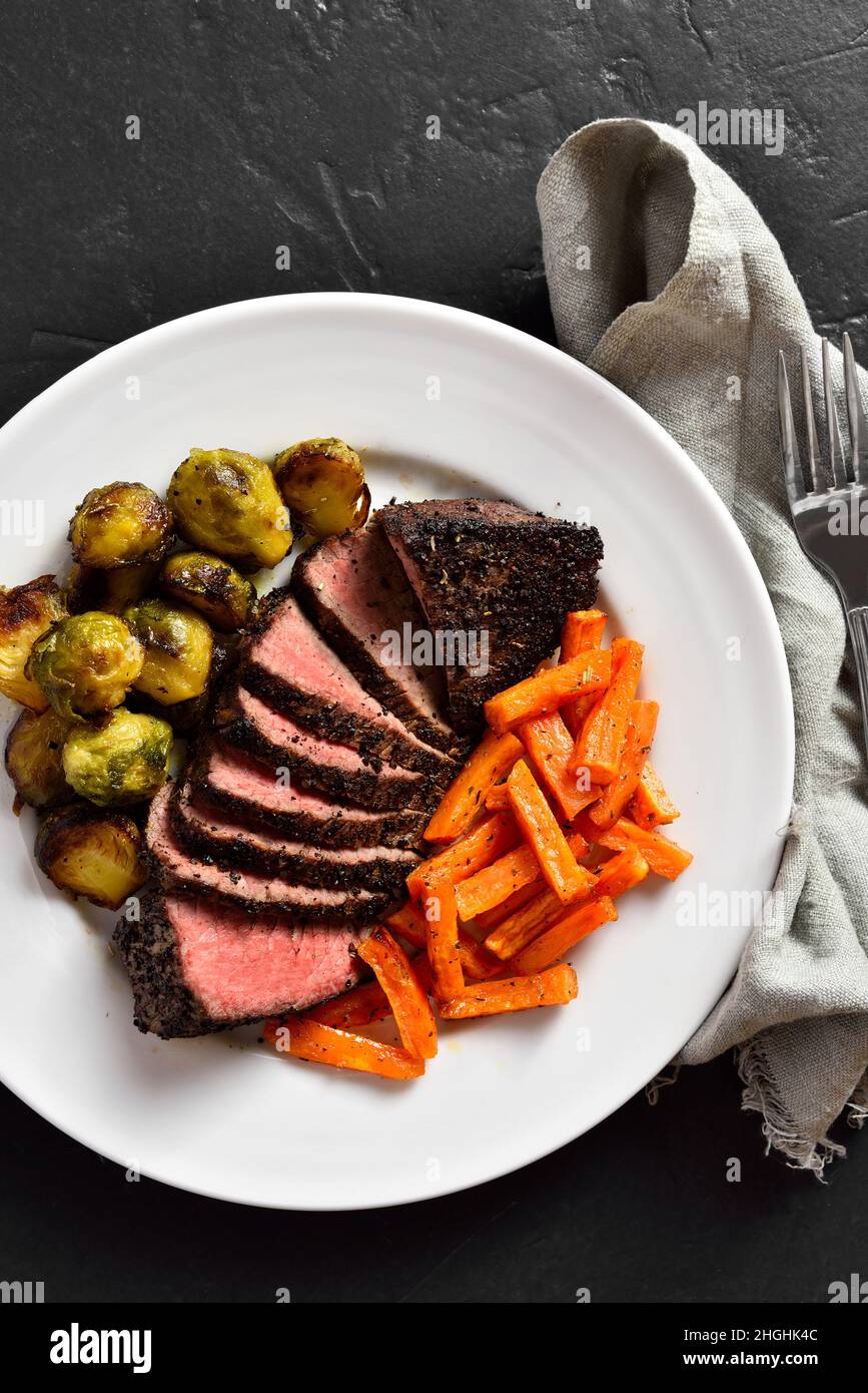 Grilled beef steak with brussels sprouts and sweet potatoes on plate
