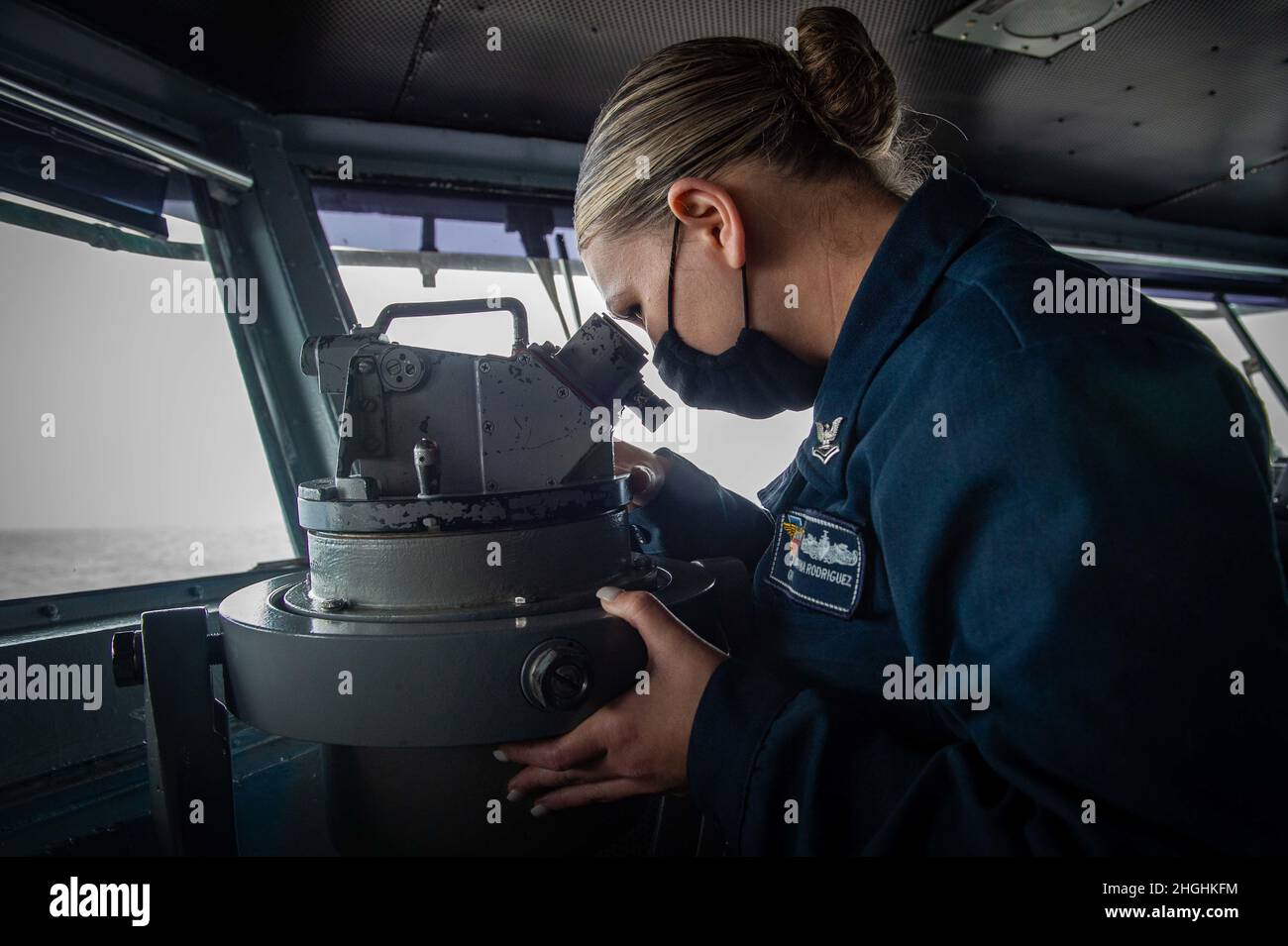 210805-N-RO680-1019 PACIFIC OCEAN (August 5, 2021) Quartermaster 2nd Class Katryna Rodriguez, a native of Boise, Idaho, looks through a telescopic alidade in the pilot house of Nimitz-class aircraft carrier USS Carl Vinson (CVN 70), August 5, 2021. The Carl Vinson Carrier Strike Group (CVCSG), led by Carrier Strike Group (CSG) 1, is deployed in support of global maritime security operations. Stock Photo