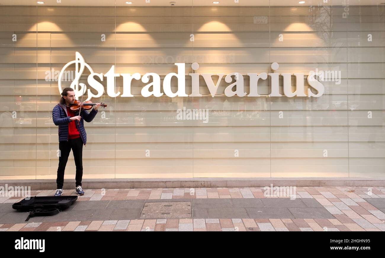 Busking with a violin outside Stradivarius clothing shop in Belfast