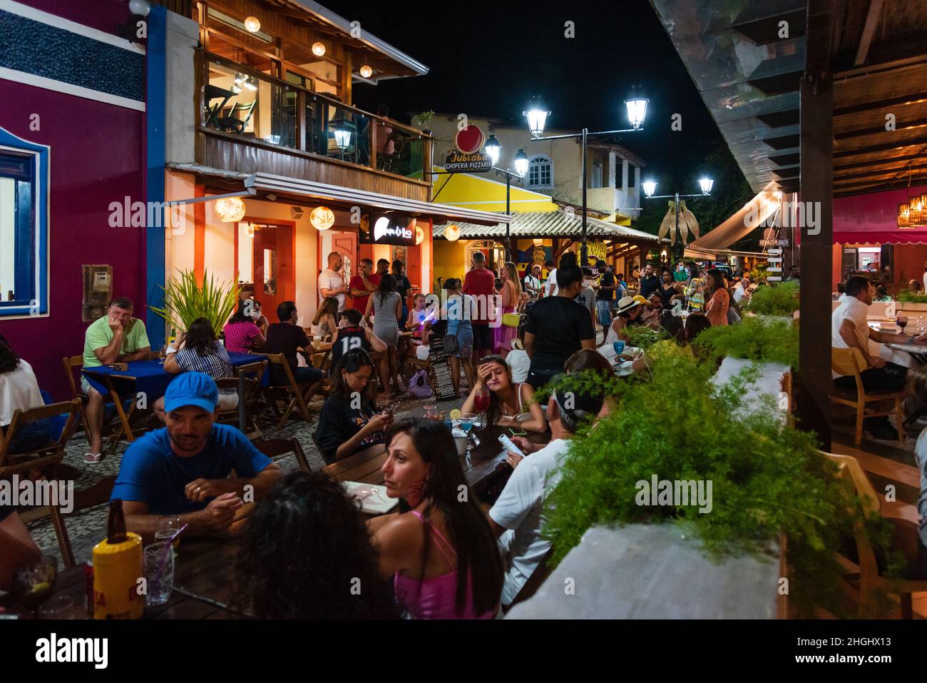Outdoor dining with people eating, drinking, talking, and walking at Beco das Garrafas in Prado, Bahia, Brazil. Stock Photo