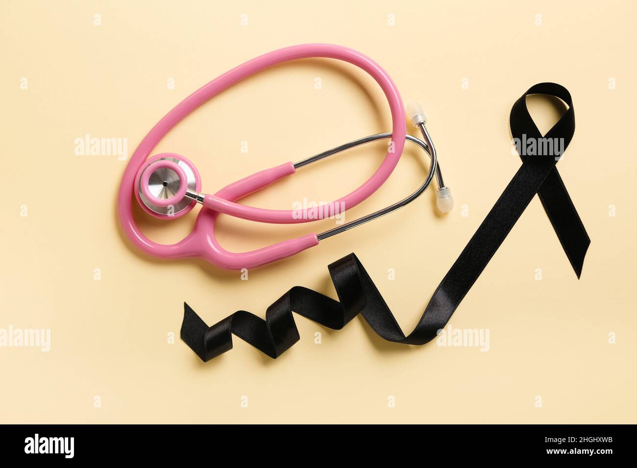 Black ribbon and stethoscope on color background. Melanoma concept ...