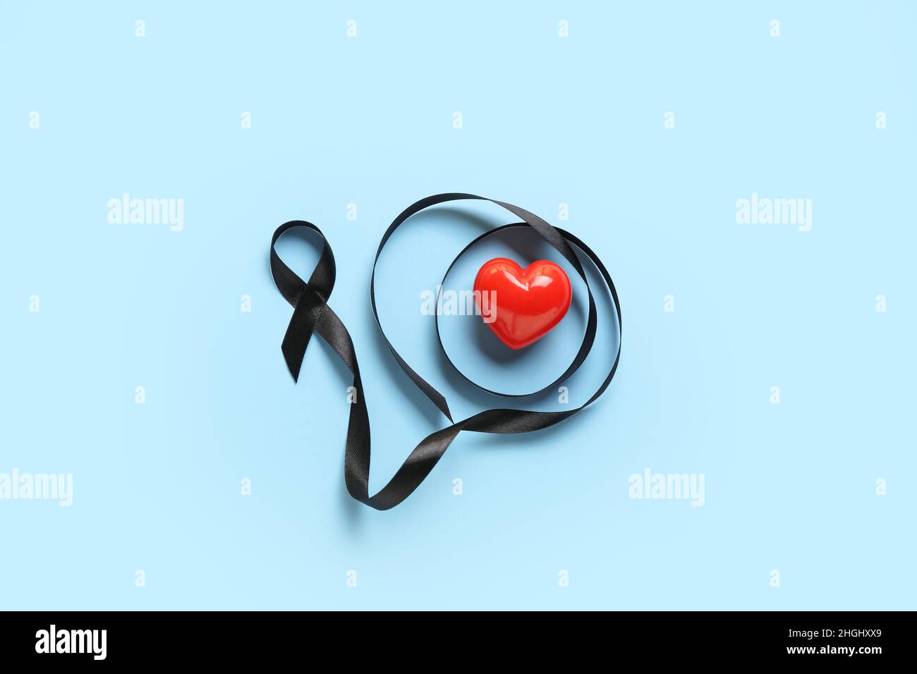 Black ribbon and heart on blue background. Melanoma concept Stock Photo ...
