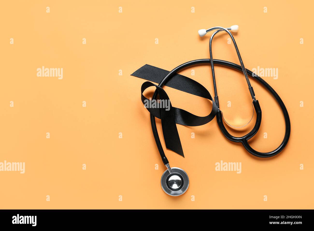 Black ribbon and stethoscope on orange background. Melanoma concept ...