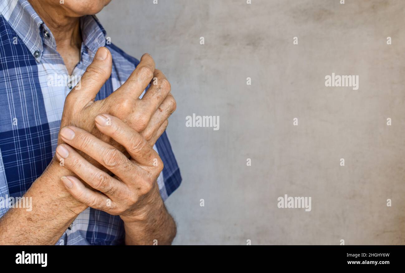 Fingers and hands of Asian elder man. Concept of hand pain, arthritis and finger problems. Text space on the right side. Stock Photo