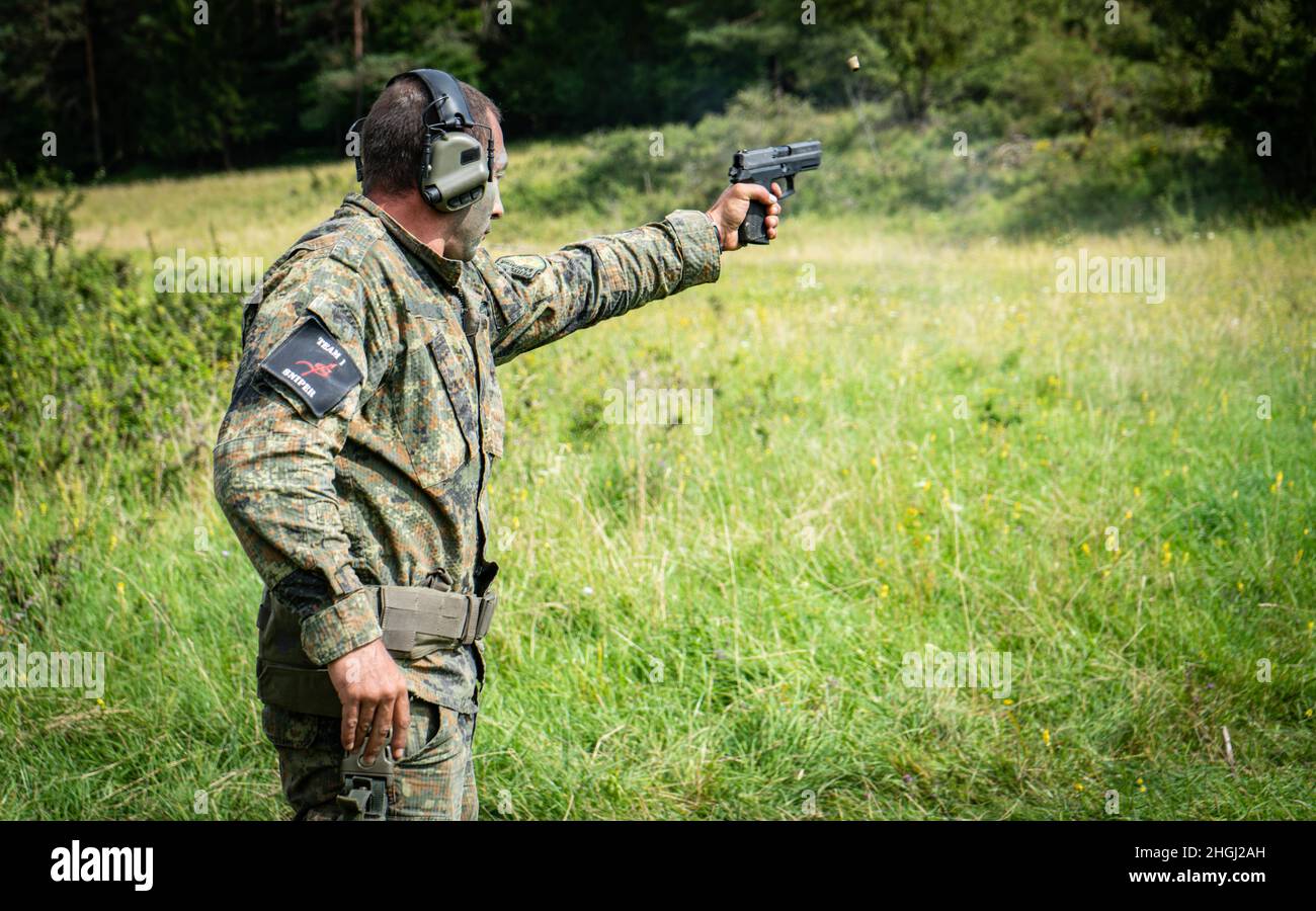 A Bulgarian soldier fires a pistol during the European Best Sniper Team Competition at Hohenfels Training Area, Germany, Aug 11, 2021. The 2021 European Best Sniper Team Competition is a U.S. Army Europe and Africa-directed, 7th Army Training Command hosted contest of skill that includes 14 participating NATO allies and partner nations at 7th ATC's Hohenfels Training Area, August 8-14. The European Best Sniper Team Competition is designed to improve professionalism and enhance esprit de corps. Stock Photo