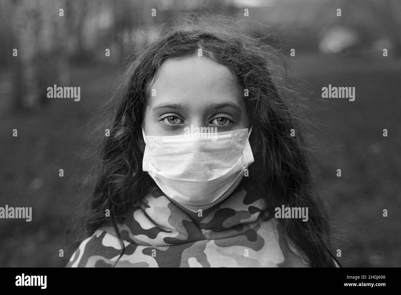 Black and white portrait sad girl  in a medical mask. Pandemic, virus, New normal concept. Stock Photo