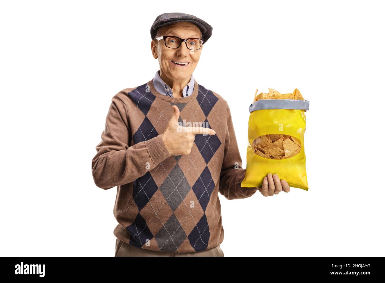 Cheerful elderly man holding a pack of tortilla chips and pointing isolated on white background Stock Photo
