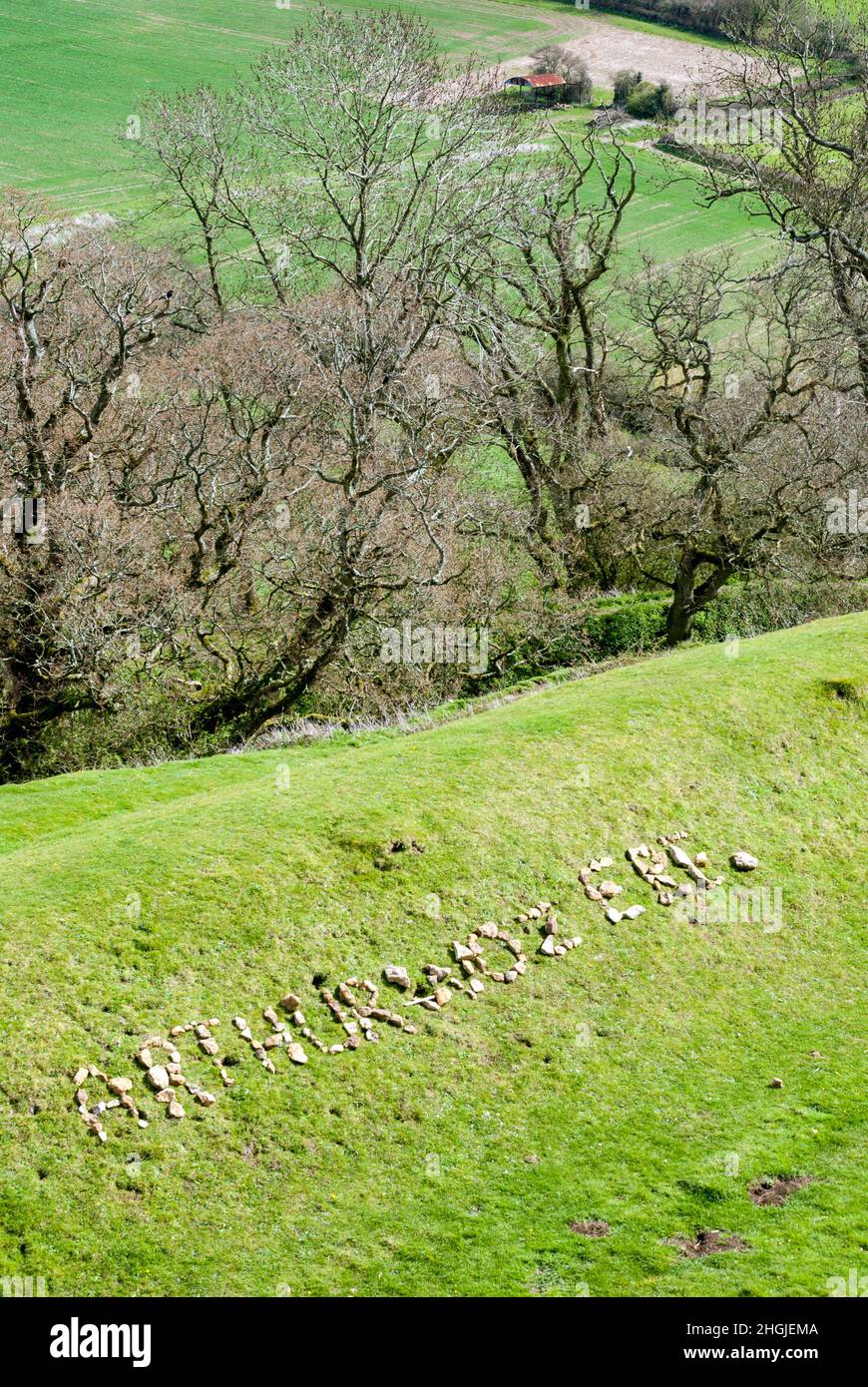 UK, England, Somerset, South Cadbury. Cadbury Castle hill fort with 'Arthur woz ere' writen in stones on the grass bank or ramparts. Stock Photo