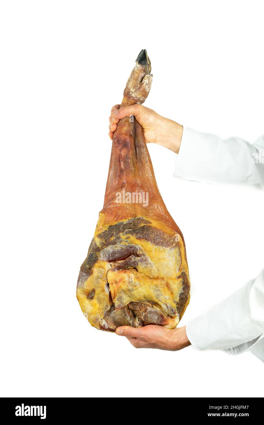 Two hands in butcher's uniform holding a cured shoulder on a white background. Stock Photo