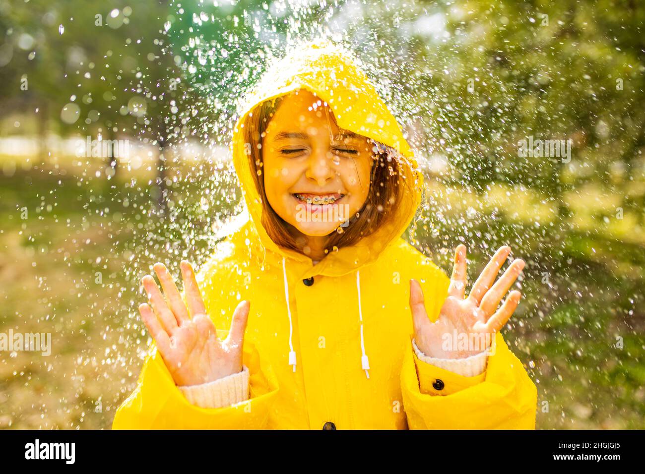 smiling teenage girl wearing raincoat outdoors in rainy day Stock Photo -  Alamy