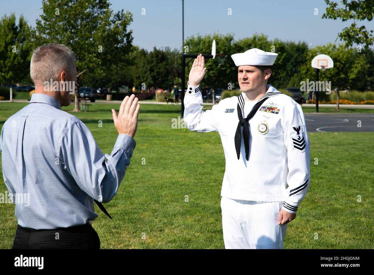MERIDIAN, ID - Navy Talent Acuisition Group Portland talent scout, First Class Navy Counselor Nicholas Humbert, recites the oath of enlistment, read by his father Robert Humbert, during a ceremony at Kleiner Park in Meridian, Idaho. The NTAG Portland Commanding Officer, Commander Brent Banks, presided over the re-enlistment ceremony. NC1 Humbert is a talent scout out of Navy Recruiting Station Boise, Idaho. (Navy photo by Dan Rachal/NTAG Portland Public Affairs) Stock Photo