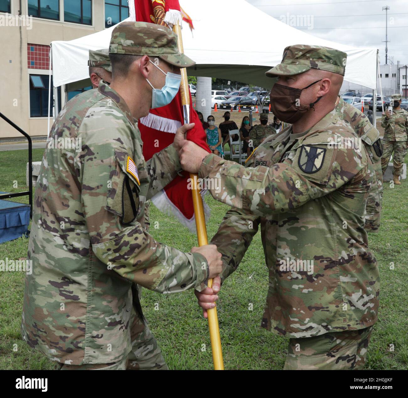 U.S. Army Reserve Command Sgt. Maj. Joshua Engel hands the guidon to Maj. James Young on August 21 2021, at Fort Shafter Flats in Honolulu.  The change of command ceremony serves as a definitive point in time, with the passing of the guidon, for the responsibility of command to pass from the old commander to the new. Stock Photo