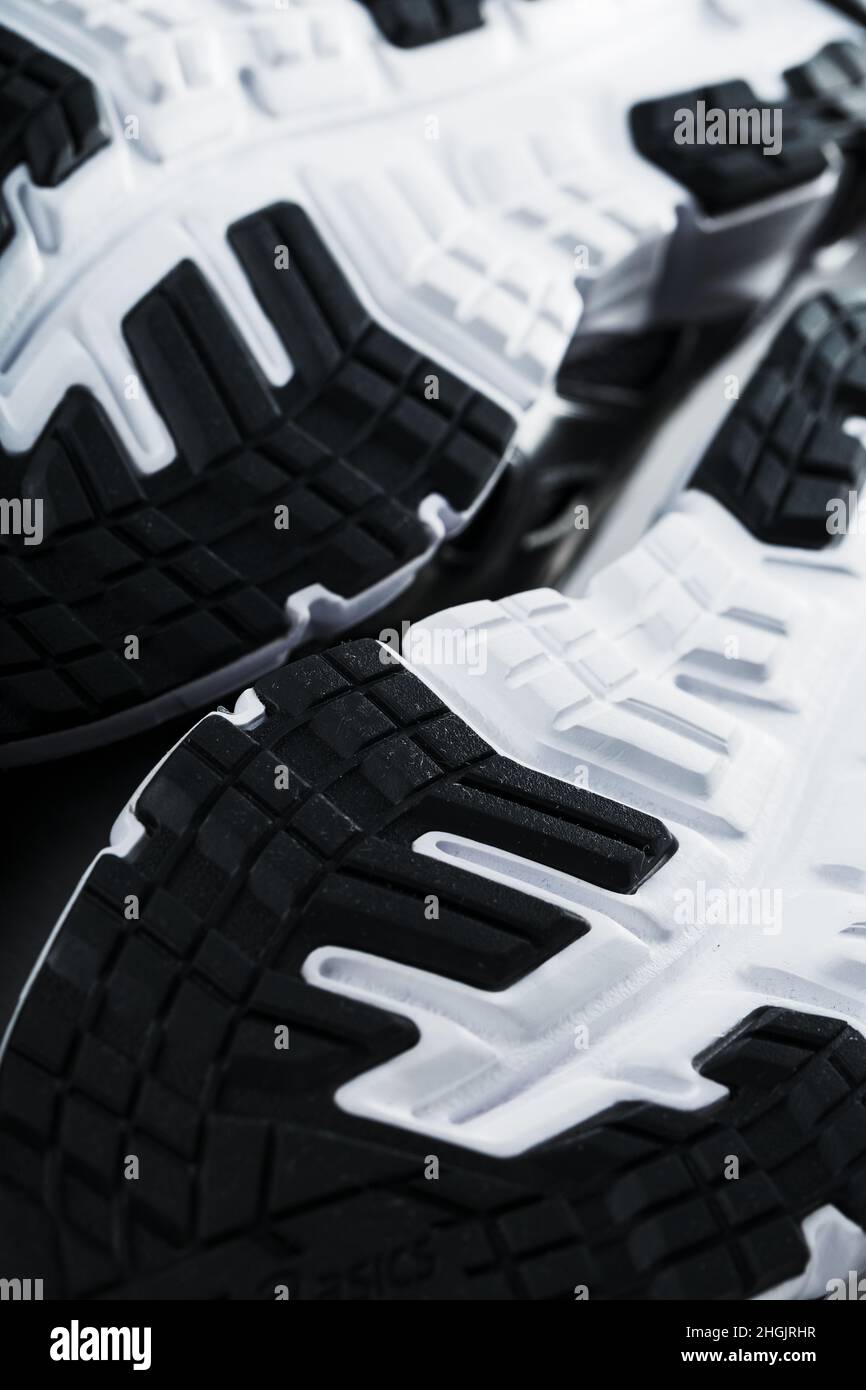 The black and white sole of trendy sports sneakers is a closeup in