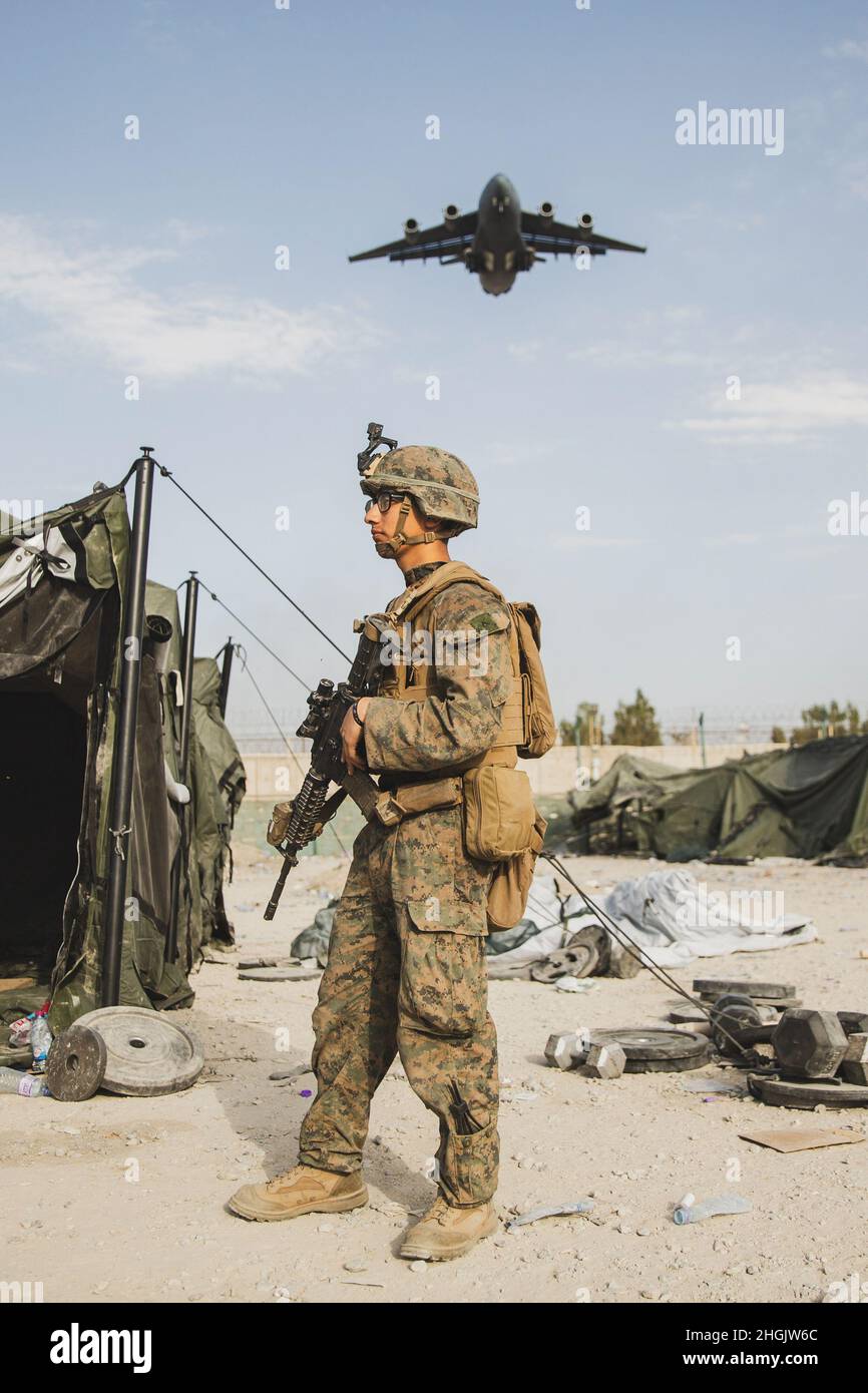 A U.S. Marine provides security assistance during an evacuation at Hamid Karzai International Airport, Kabul, Afghanistan, Aug. 24. U.S. service members and coalition forces are assisting the Department of State with a non-combatant evacuation operation (NEO) in Afghanistan. Stock Photo