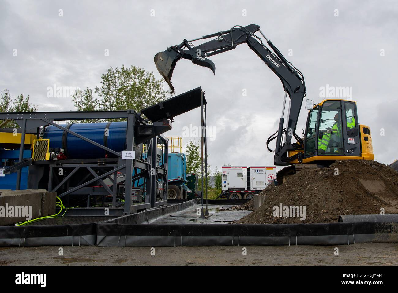 Contaminated soil is loaded into a decontamination machine during a