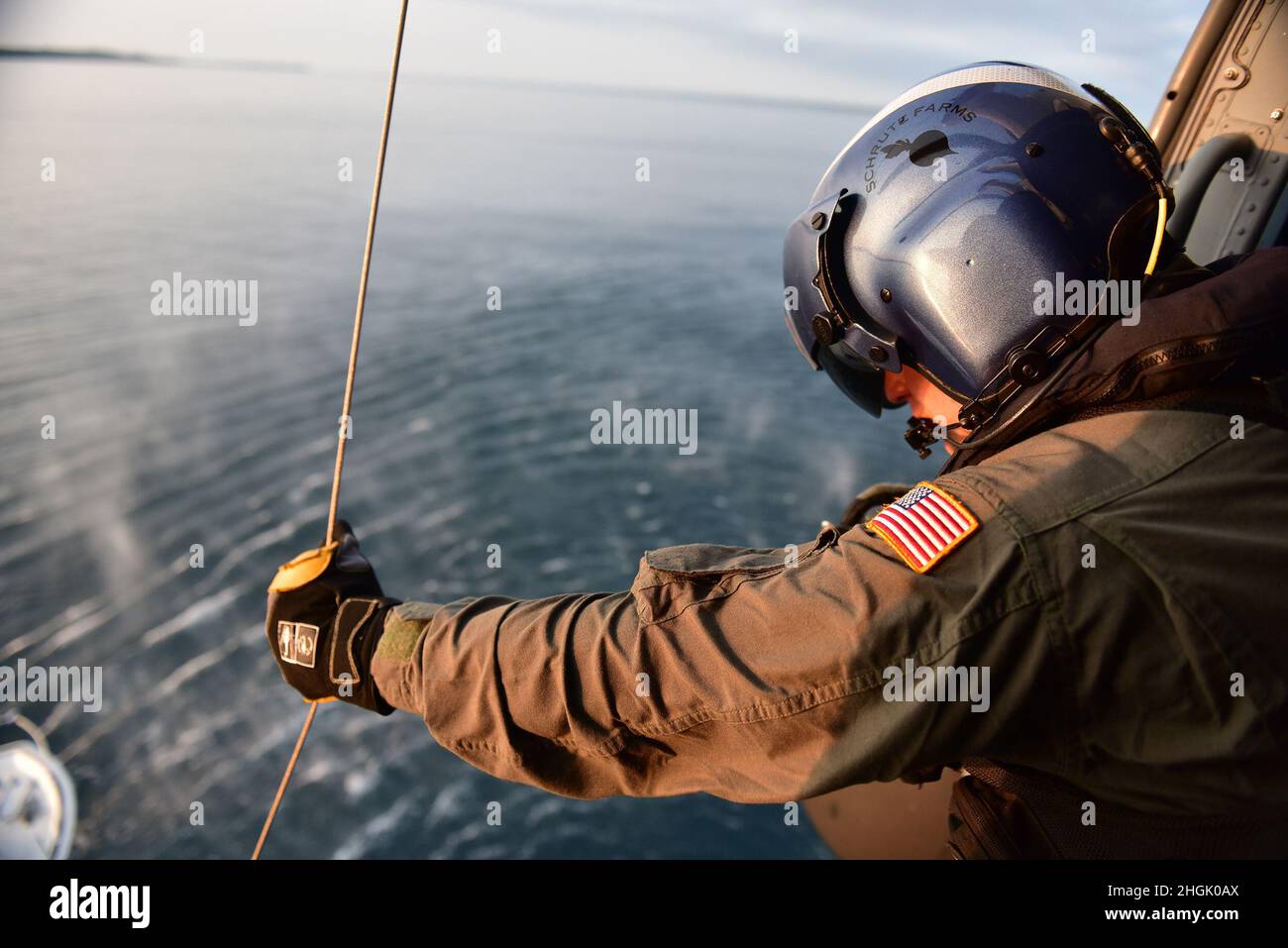 Petty Officer 2nd Class Benjamin Davis tends the hoist cable during training over Lake Michigan