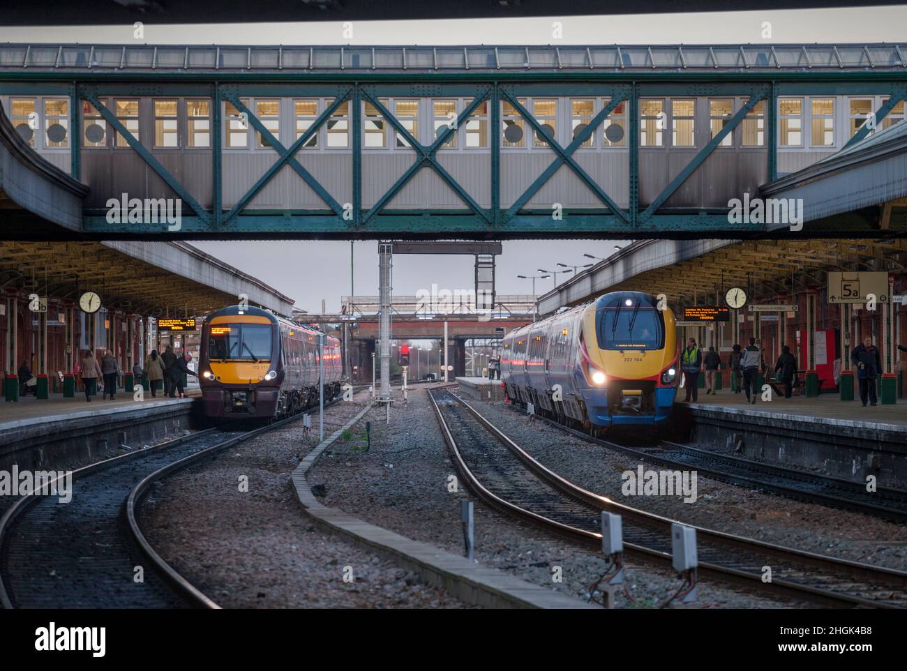 Crosscountry trains and  East Midlands railway trains connecting at Nottingham railway station with analogue railway station clocks. Stock Photo