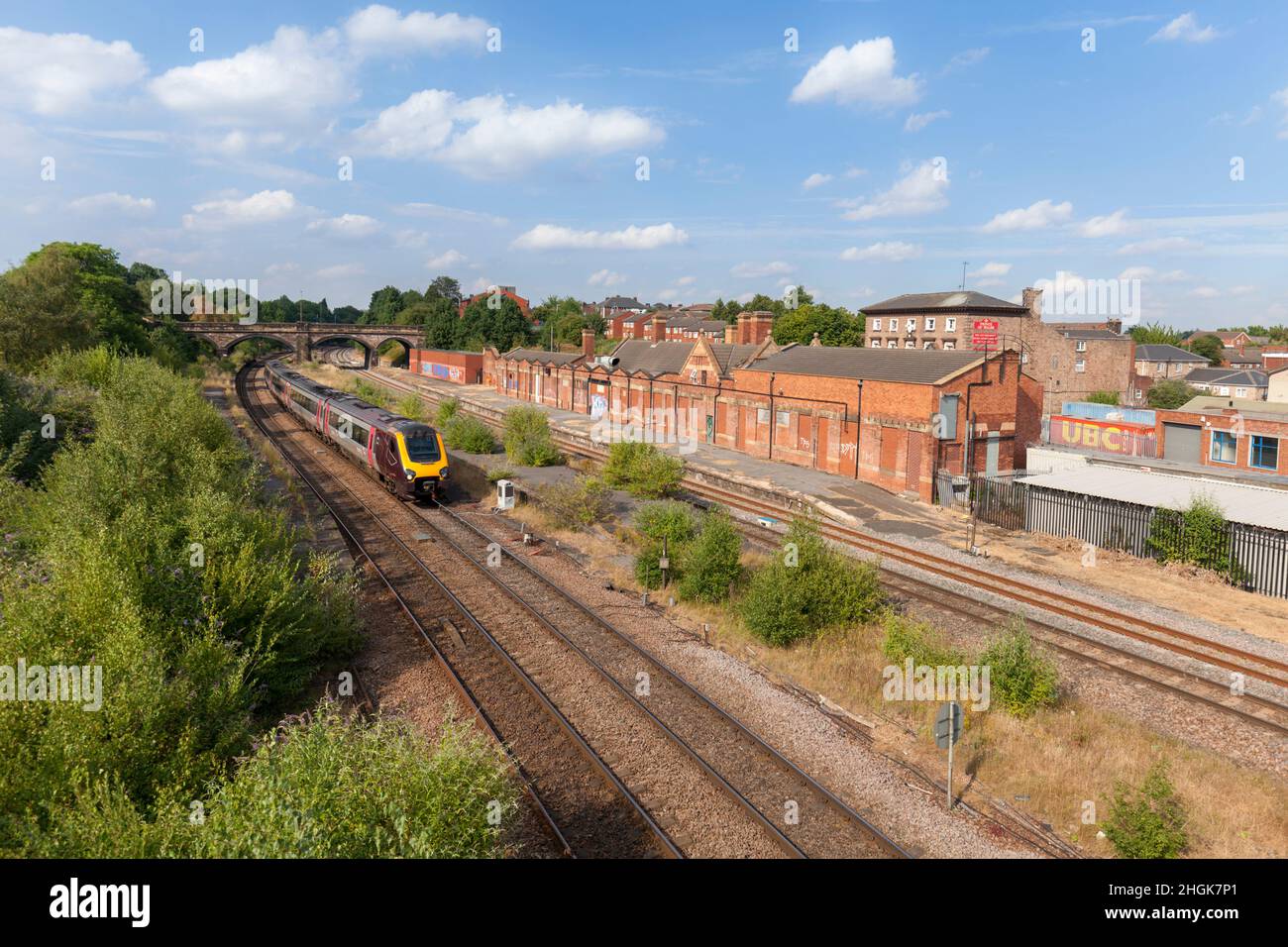 A Crosscountry Trains class 220 voyager train passing the derelict closed railway station at Rotherham Masborough Stock Photo