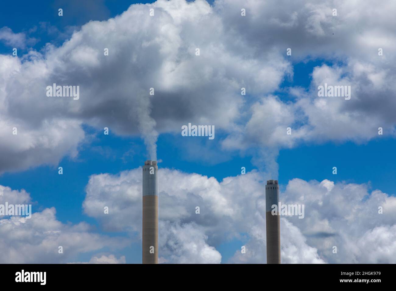 Smoke rising from two smoke stacks into the atmosphere.  Concept for greenhouse gasses creating global warming Stock Photo