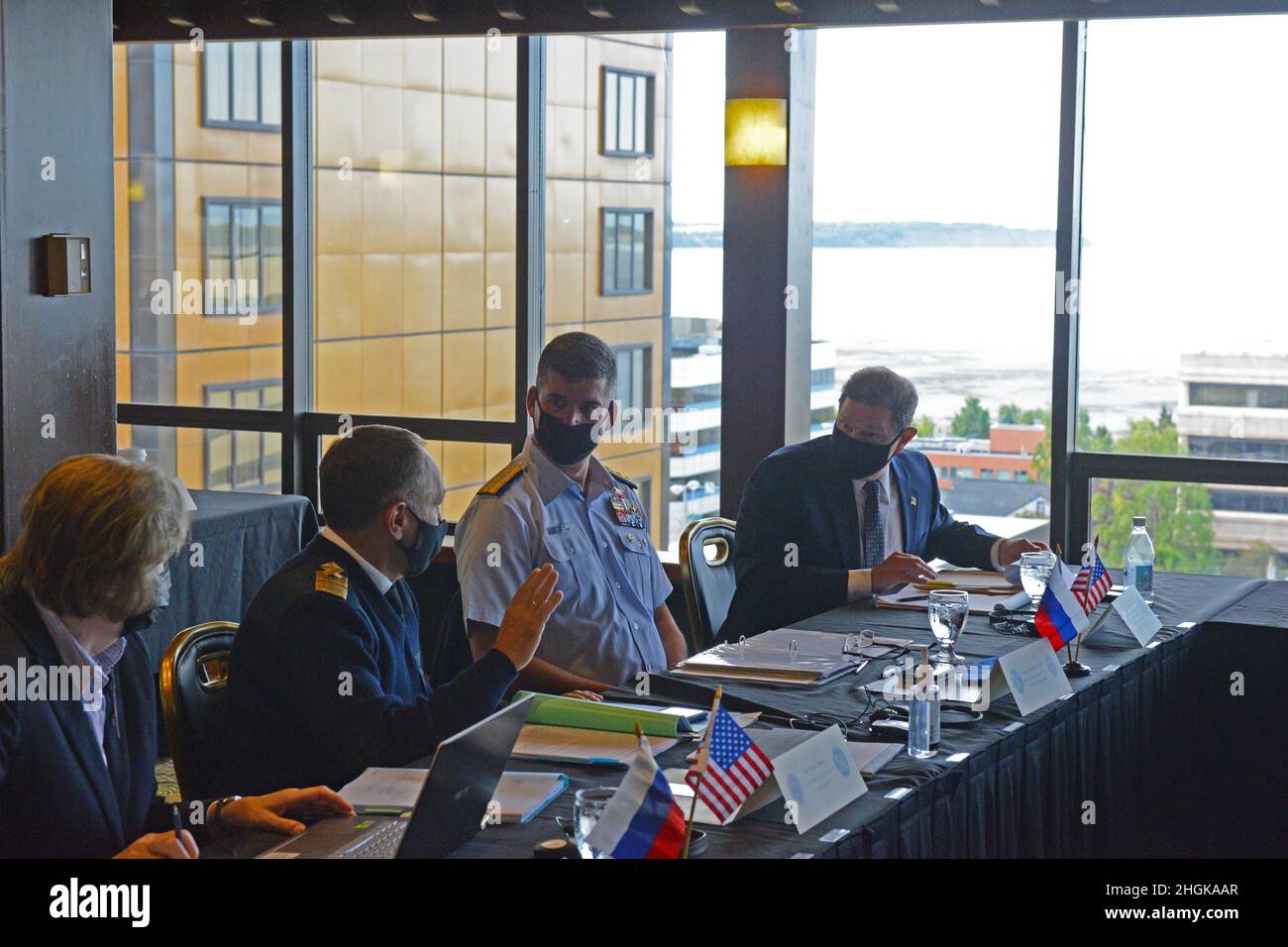 Rear Adm. Nathan A. Moore, commander, Seventeenth Coast Guard District, discusses plans with Mr. Petr Gerasun, deputy director, Russian Federation Marine Rescue Service, during the 43rd Joint Planning Group meeting at Captain Cook Hotel in Anchorage, Alaska, Sept. 1, 2021. Members of the U.S. Coast Guard and Russian Federation delegation participated in the 43rd Joint Planning Group meeting for pollution preparedness and response cooperation in the Bering Sea and Chukchi Seas. Stock Photo