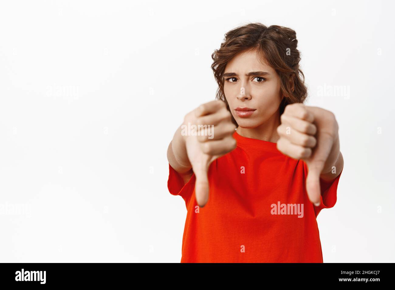 Young woman express dislike, showing thumbs down, disapprove, prohibit ...