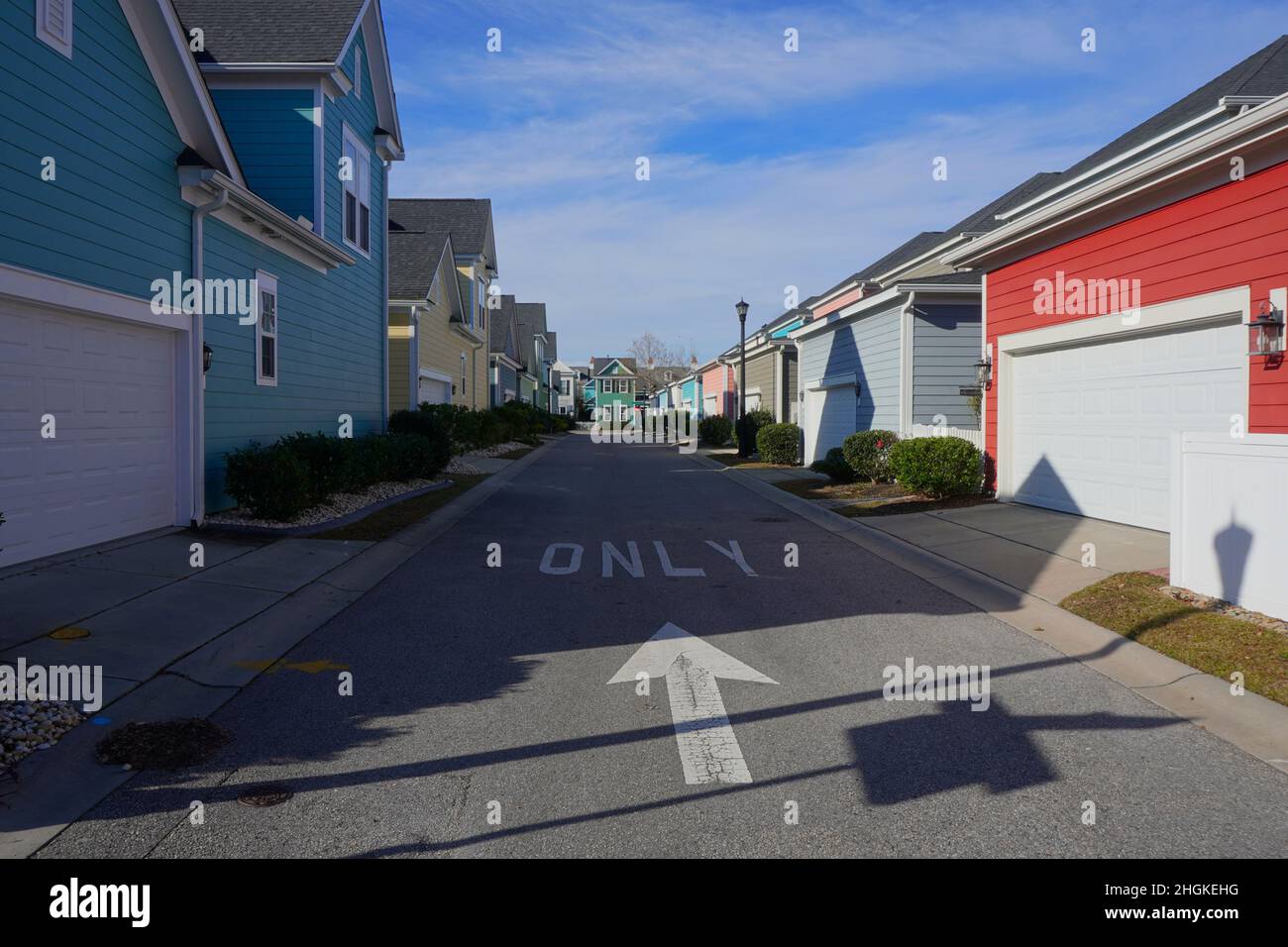 One-way alley through a suburban neighborhood showing a row of colorful garages. Stock Photo