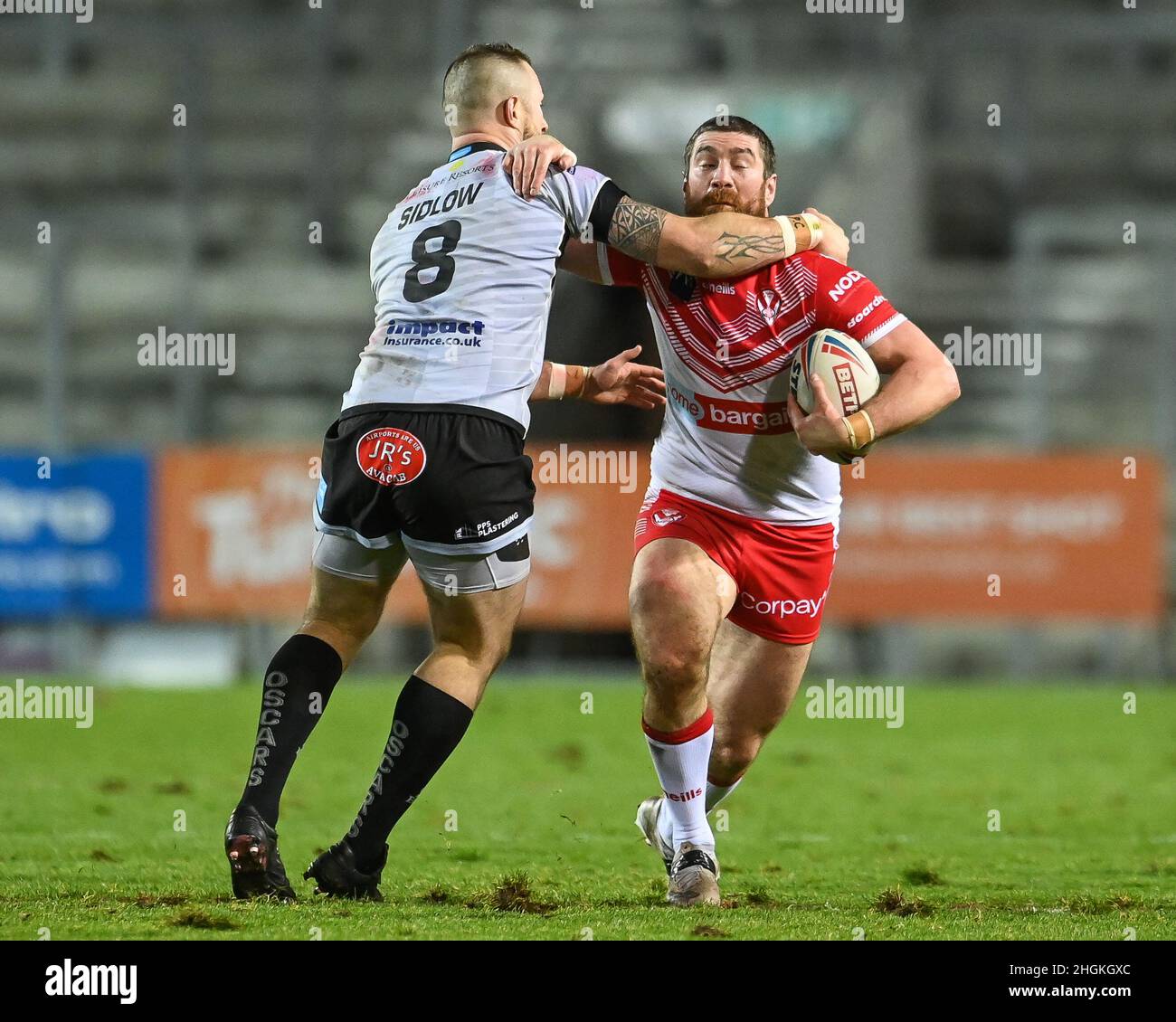Kyle Amor (18) of St Helens is tackled by Adam Sidlow (8) of Leigh ...