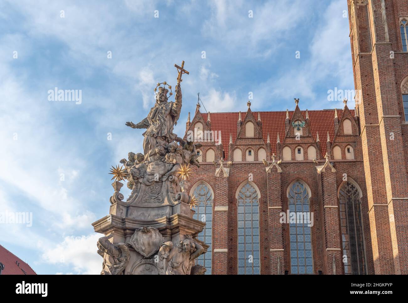 Statue of St. John Nepomuk and Collegiate Church of the Holy Cross at Cathedral Island (Ostrow Tumski) - Wroclaw, Poland Stock Photo