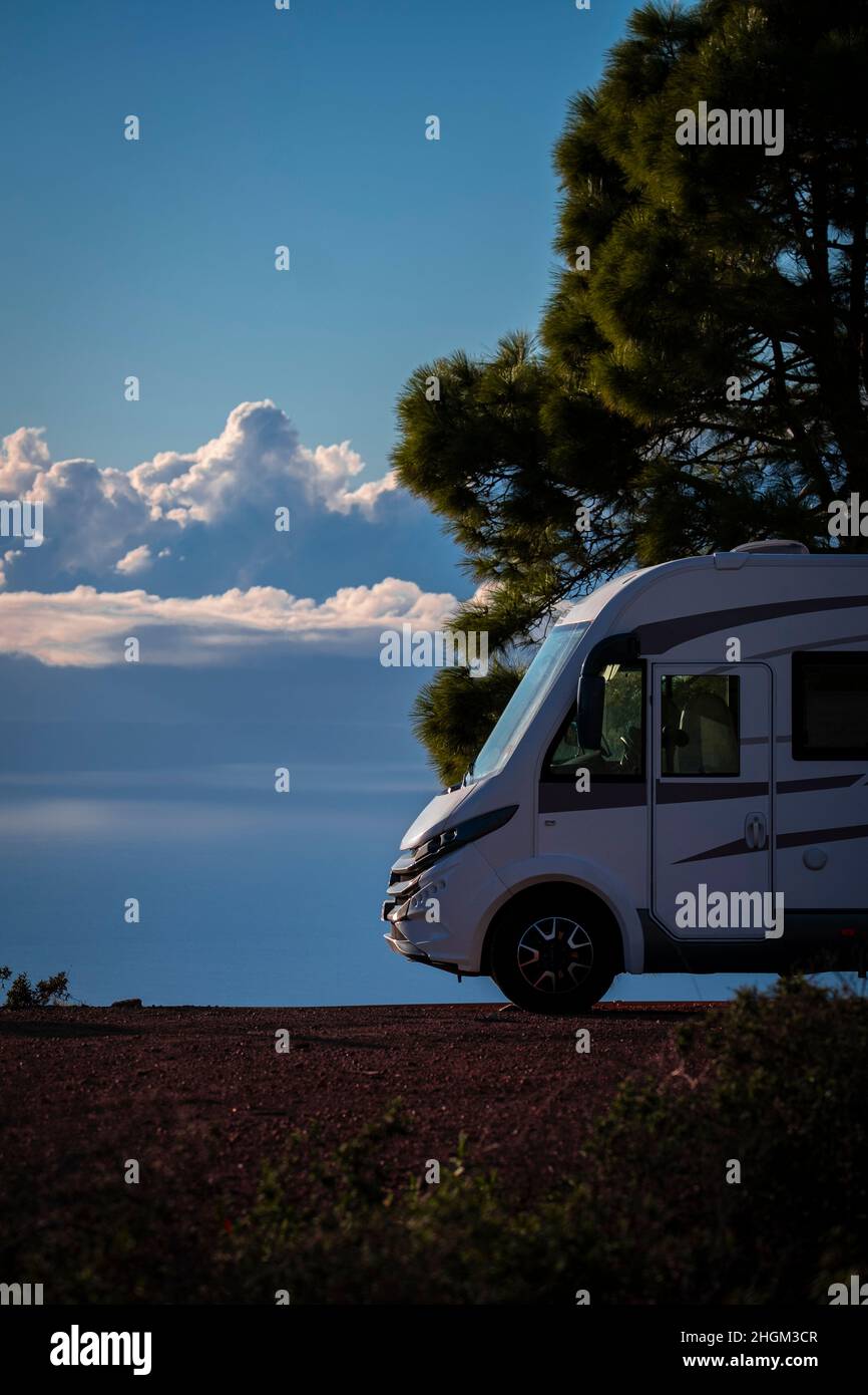Modern elegant motorhome cozy home parked off road with blue sky and clouds in background. Concept of freedom and travel lifestyle for alternative peo Stock Photo