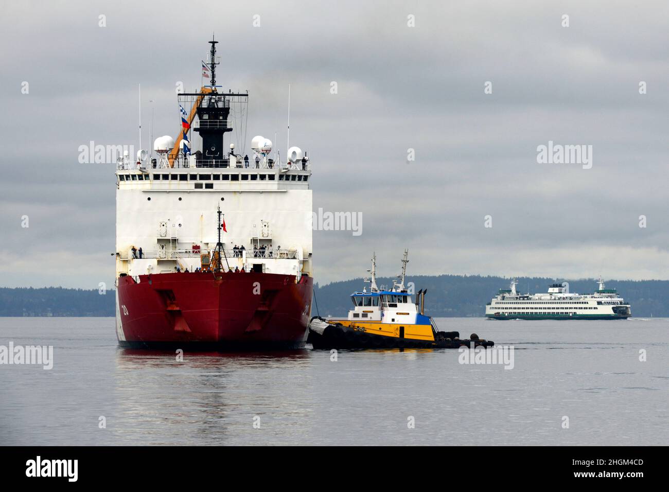Seattle, United States. 20 November, 2021. A tug boat assists the U.S. Coast Guard Cutter Healy, as it returns to homeport at the Base Seattle pier following a 22,000-mile, 133-day deployment circumnavigating North America, November 20, 2021 in Seattle, Washington. Credit: PO3 Michael Clark/US Coast Guard Photo/Alamy Live News Stock Photo