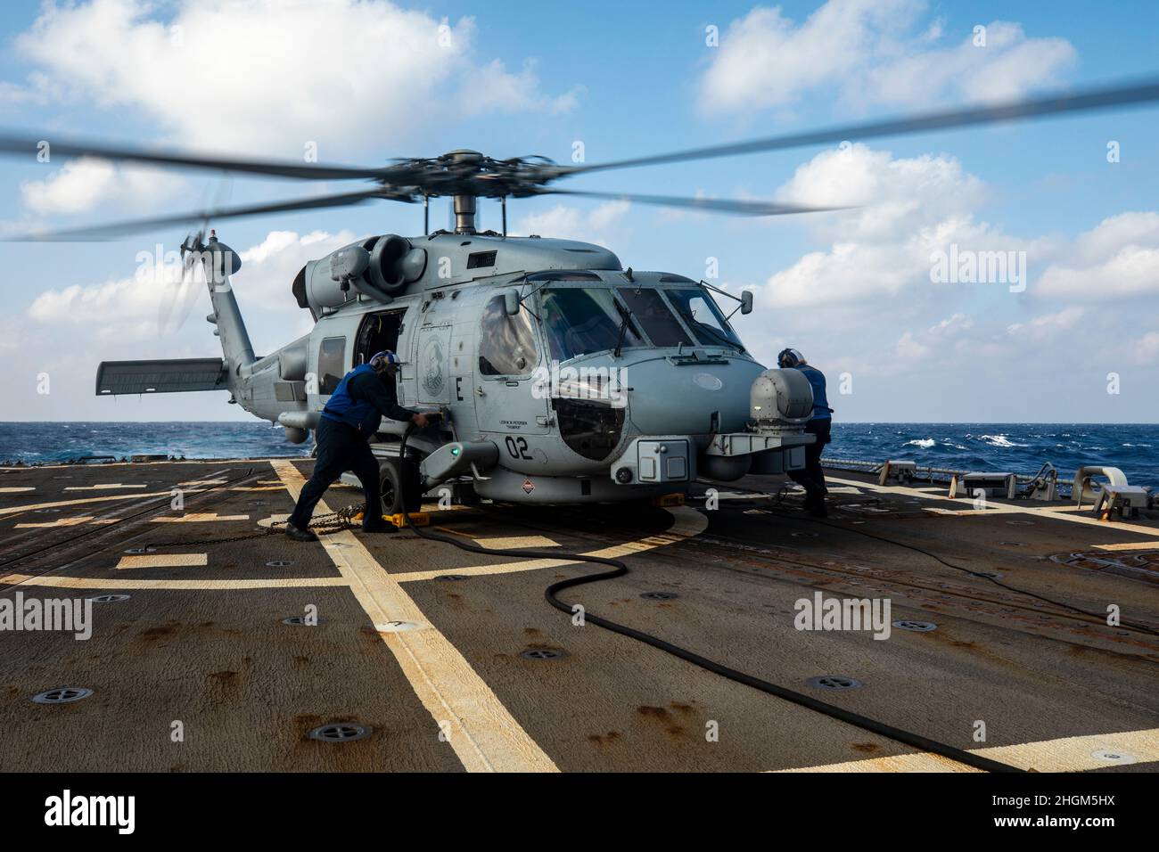 SOUTH CHINA SEA (Jan. 19, 2022) Sailors ready an MH-60R helicopter for take-off during flight operations aboard Arleigh Burke-class guided-missile destroyer USS Ralph Johnson (DDG 114). Ralph Johnson is assigned to Task Force 71/Destroyer Squadron (DESRON) 15, the Navy’s largest forward-deployed DESRON and the U.S. 7th fleet’s principal surface force. (U.S. Navy photo by Mass Communication Specialist 2nd Class Samantha Oblander) Stock Photo