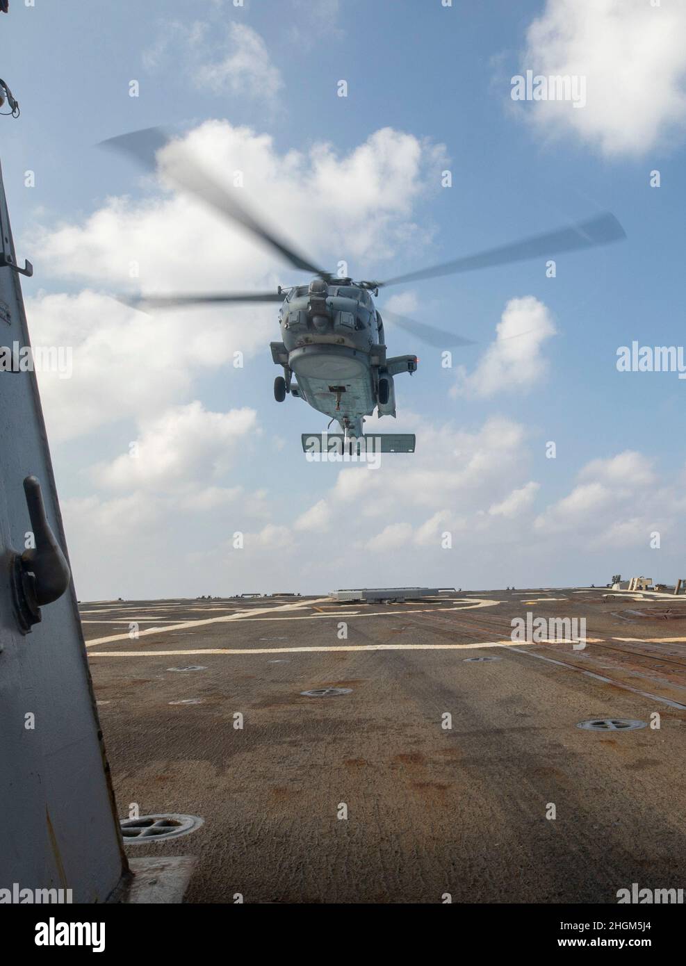 SOUTH CHINA SEA (Jan. 19, 2022) An MH-60R helicopter lifts off the deck of Arleigh Burke-class guided-missile destroyer USS Ralph Johnson (DDG 114) during flight operations. Ralph Johnson is assigned to Task Force 71/Destroyer Squadron (DESRON) 15, the Navy’s largest forward-deployed DESRON and the U.S. 7th fleet’s principal surface force. (U.S. Navy photo by Mass Communication Specialist 2nd Class Samantha Oblander) Stock Photo