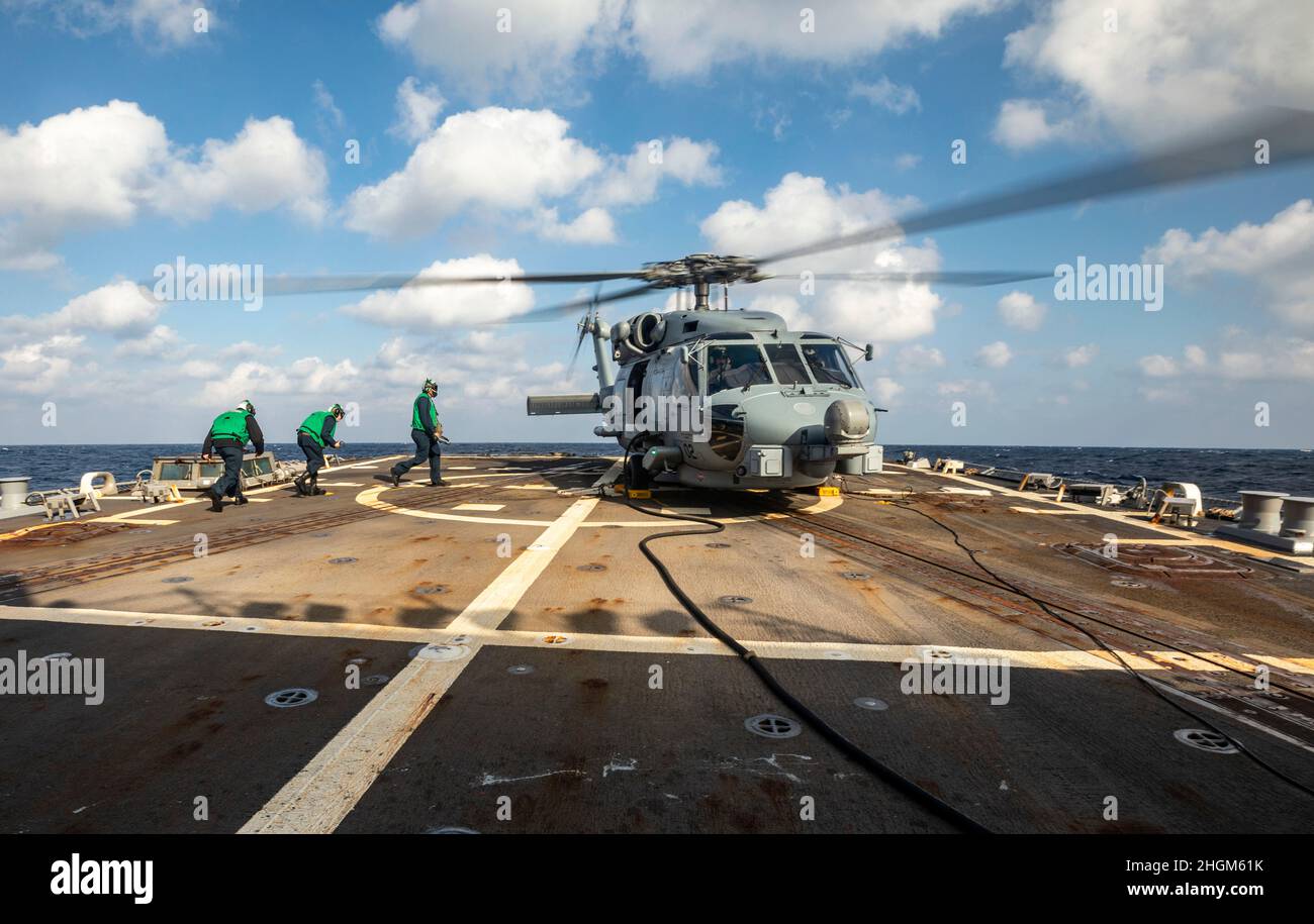 SOUTH CHINA SEA (Jan. 19, 2022) Sailors walk to an MH-60R helicopter during flight operations aboard Arleigh Burke-class guided-missile destroyer USS Ralph Johnson (DDG 114). Ralph Johnson is assigned to Task Force 71/Destroyer Squadron (DESRON) 15, the Navy’s largest forward-deployed DESRON and the U.S. 7th fleet’s principal surface force. (U.S. Navy photo by Mass Communication Specialist 2nd Class Samantha Oblander) Stock Photo