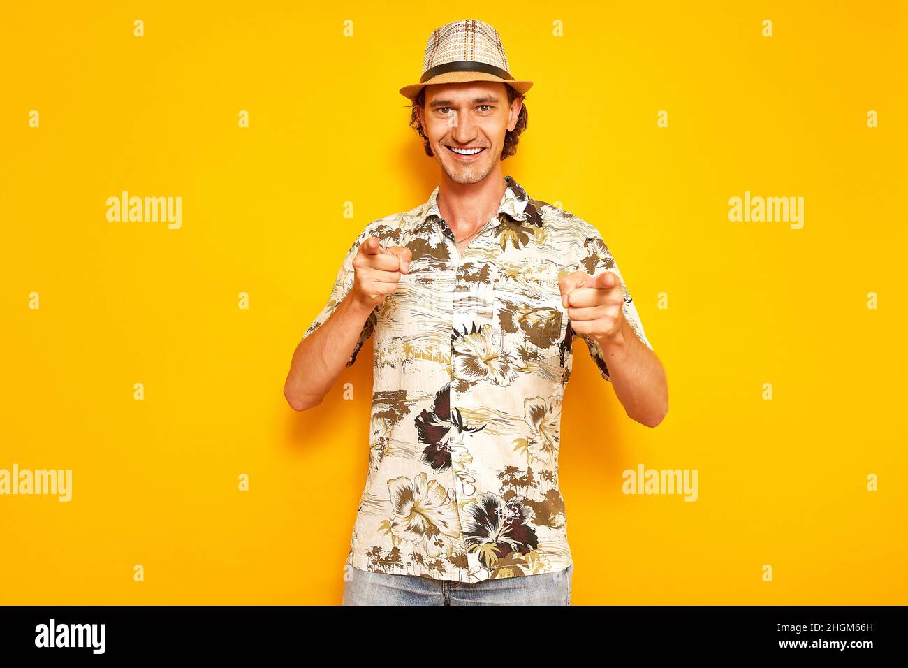 studio portrait of joyful smiling male traveler tourist, holding his index fingers in front of him Stock Photo