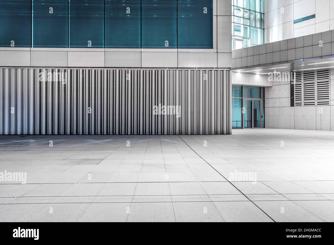 Empty square floor and modern commercial office building at night Stock Photo