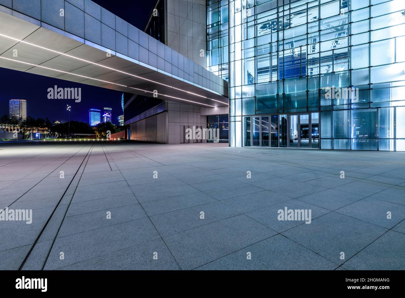 Empty square floor and modern commercial office building at night Stock Photo