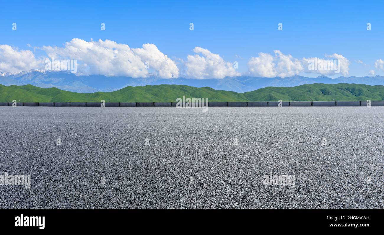 Asphalt road and mountain under blue sky Stock Photo - Alamy