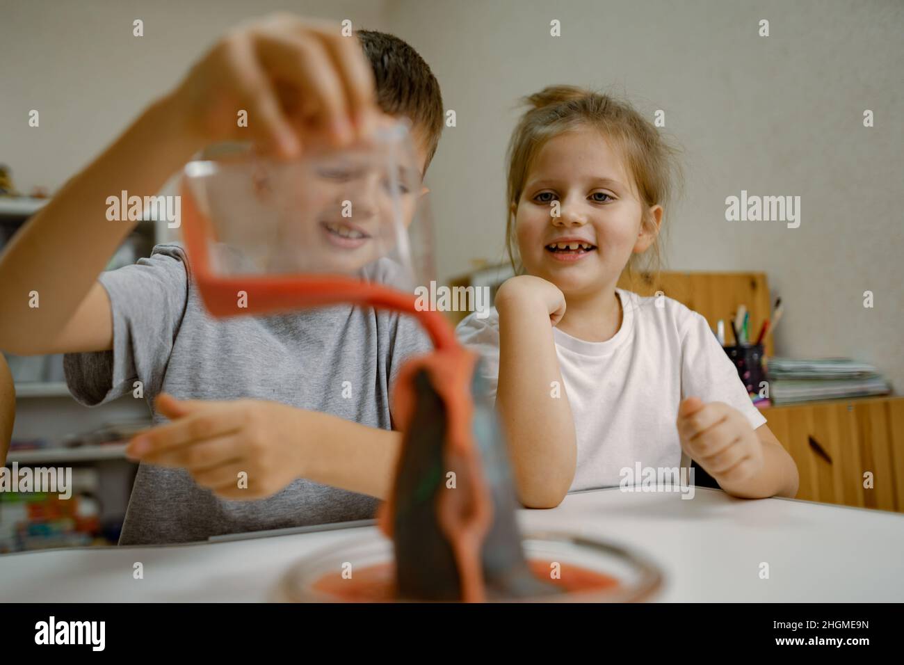 Children, boy and girl are conducting an experiment with volcanic eruption at home Stock Photo