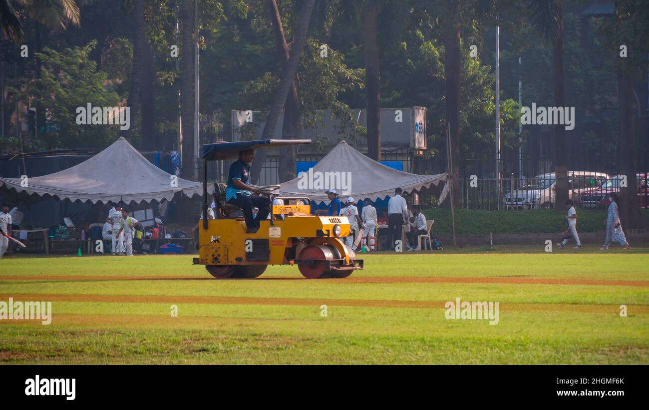 MUMBAI, INDIA - November 26, 2021 : A groundsman rolling the wicket to prepare a cricket pitch at Mumbai ground Stock Photo