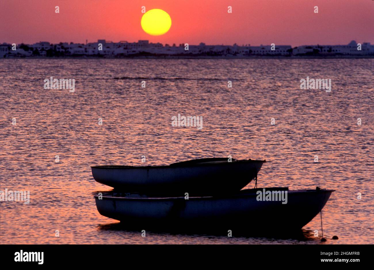 Dinghy boats and coastal sunset, Djerba, Tunisia Stock Photo